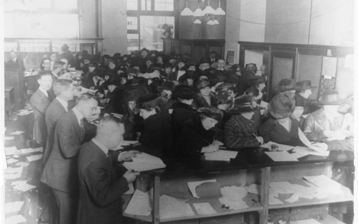 Clerks sorting income tax forms at a desk in 1920
